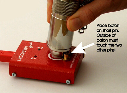 Place the baton on the short pin, with its side touching the other two pins