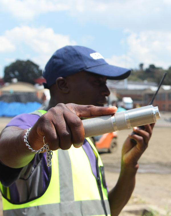 A security guard holding out a stainless steel patrol baton